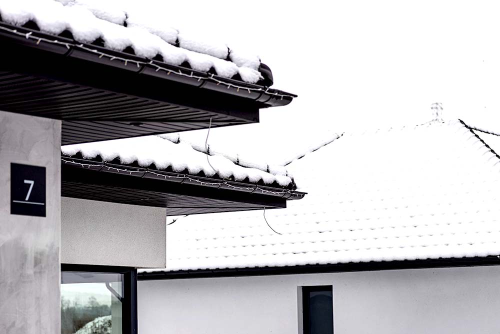 Roof of a residential home covered in snow